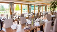 Un comedor con mesas y sillas y ventanas. en Shendish Manor Hotel & Golf Course, en Hemel Hempstead