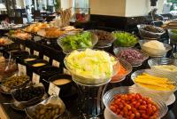 Un buffet con muchos tazones de diferentes tipos de comida. en Cape Racha Hotel, en Si Racha