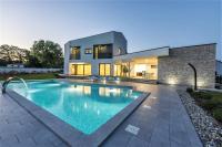 a swimming pool in front of a house at Contemporary Villa Nada with Pool and Sauna in Tinjan