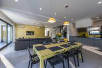 a dining room and kitchen with a yellow table and chairs at Contemporary Villa Nada with Pool and Sauna in Tinjan