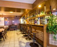 a restaurant with a row of bar stools at Hotel Le Postillon in Esch-sur-Sûre