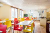 a dining room with tables and colorful chairs at Premiere Classe Annecy Nord - Epagny in Épagny