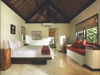 a bedroom with a large bed and a red couch at Qunci Villas Resort in Senggigi