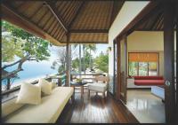 a living room with a couch and a view of the ocean at Qunci Villas Resort in Senggigi