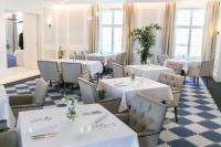 een restaurant met witte tafels, stoelen en ramen bij Pałac Komierowo in Sępólno Krajeńskie