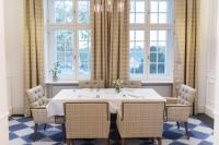 een eetkamer met een tafel, stoelen en ramen bij Pałac Komierowo in Sępólno Krajeńskie