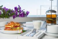 a sandwich on a plate next to a glass of milk at Design Hotel Skopeli in Odesa