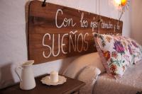a sign on a wall above a couch with a candle on a table at La Carrihuela in Algodonales