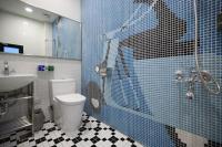 a blue tiled bathroom with a toilet and a sink at 321 Apartment B&amp;B in Hualien City