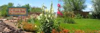 einen Garten mit Schild und Blumen im Hof in der Unterkunft La Posada Hotel and Gardens in Winslow