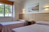 A bed or beds in a room at Duerming San Vicente Hotel