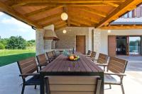 an outdoor dining room with a wooden table and chairs at Villa Mattina in Nedeščina