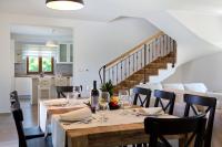 a dining room with a table and chairs and a staircase at Villa Mattina in Nedeščina