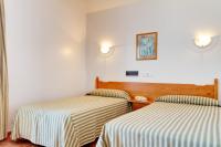 A bed or beds in a room at Duerming San Vicente Hotel