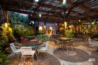 a patio with tables and chairs and plants at Hotel de Lençois in Lençóis