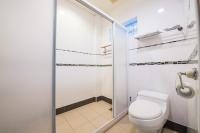 a bathroom with a toilet and a glass shower at Ribbed Birch B&amp;B in Hualien City