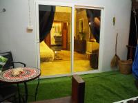 a room with a door with a table and green carpet at Oon Lee Bungalows in Ko Jum