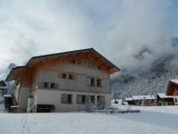 a house in the snow with mountains in the background at Apartment La Tibolire in Sixt