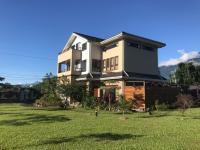 a large house with a grass yard in front of it at Celine&#39;s B&amp;B in Fenglin