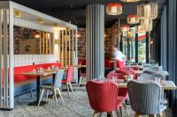 Un restaurante con mesas y sillas y una persona al fondo. en Best Western Montecristo-Bastia, en Bastia