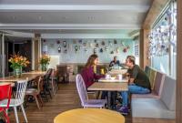 a group of people sitting at tables in a restaurant at Hotel Espresso in Amsterdam