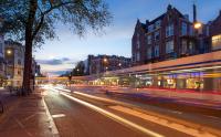 a city street at night with a train at Hotel Espresso in Amsterdam