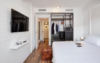 a bedroom with a bed and a tv on a wall at Delamar 4*Sup-Adults only (18+) in Lloret de Mar