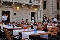 a room with tables and chairs with people in a building at The Pucic Palace in Dubrovnik