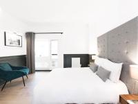 a bedroom with a white bed and a blue chair at LivinParis - Luxury 3 Bedrooms République I in Paris