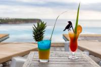 dois cocktails numa mesa com vista para o mar em Le Rayon Vert - Hôtel & Restaurant VUE SUR MER em Deshaies