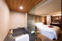 a bathroom with a bed and a tub in a room at Beitou Hot Spring Resort in Taipei