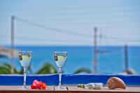 dos copas de vino sentadas en una mesa cerca del océano en Sea View Apartments &amp; Studios, en Agia Anna de Naxos