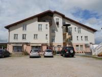 Un gran edificio con coches aparcados en un estacionamiento. en Hotel Narcea, en Valles