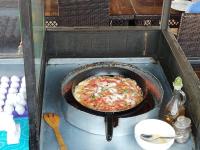 Bedouin Garden Village, hotel Dive في العقبة: بيتزا في مقلاة على موقد لعبة