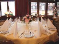 Una mesa de comedor con servilletas blancas y flores. en Hotel Felsenkeller, en Rüdesheim am Rhein