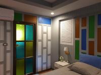 a bedroom with colorful glass panels on the wall at Baan Baimai Boutique Room in Phra Nakhon Si Ayutthaya