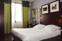 Un dormitorio con una gran cama blanca y una ventana. en Hôtel Du Centre Annemasse, en Annemasse