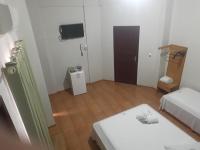 Una pequeña habitación blanca con una cama y una mesa. en Hotel Chalé Ji-Parana, en Ji-Paraná