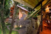 an outdoor patio with a stone wall and a restaurant at SWP Eco Lodge in Kandy