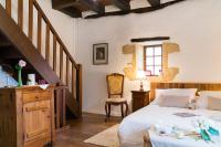 a bedroom with a bed and a stair case at Au coeur de Beynac, une maison de caractère avec jardin terrasse in Beynac-et-Cazenac