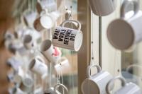 a bunch of coffee cups hanging in a window at Hotel Espresso in Amsterdam