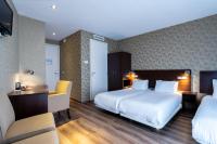 a hotel room with two beds and a desk and chairs at Hotel Espresso in Amsterdam