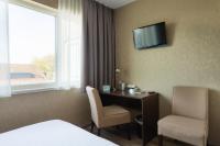 a hotel room with a desk and a television on the wall at Hotel Espresso in Amsterdam