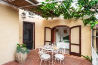 a patio with a table and chairs and a bed at Casa Claudius - Positano in Positano