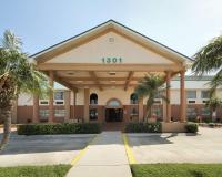 Un edificio con palmeras delante. en Americas Best Value Inn Pharr&#47;McAllen, en Pharr