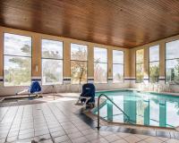 a swimming pool with two chairs and a table at Quality Inn Airport in Colorado Springs
