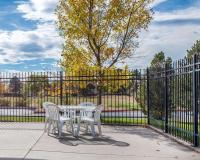 a table and two chairs in front of a fence at Quality Inn Airport in Colorado Springs