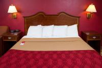 Bett in einem Hotelzimmer mit einer roten Wand in der Unterkunft Econo Lodge Sturbridge Route 20 in Sturbridge