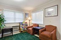 ein Wohnzimmer mit zwei Stühlen und einem Kamin in der Unterkunft Econo Lodge Sturbridge Route 20 in Sturbridge