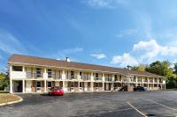 ein großes Gebäude mit einem auf einem Parkplatz geparkten Auto in der Unterkunft Econo Lodge Sturbridge Route 20 in Sturbridge